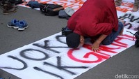 Badan Eksekutif Mahasiswa (BEM) menjadikan spanduk bertuliskan JOKOWI-JK GAGAL sebagai alas untuk salat.