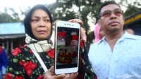 Seorang warga menunjukkan foto keluarganya yang menaiki pesawat Lion Air.