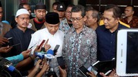 Amien tampak mengenakan kemeja putih lengan panjang dan peci berwarna hitam.