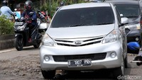 Kendaraan yang lalu lalang pun harus berhati-hati saat melalui jalan itu.