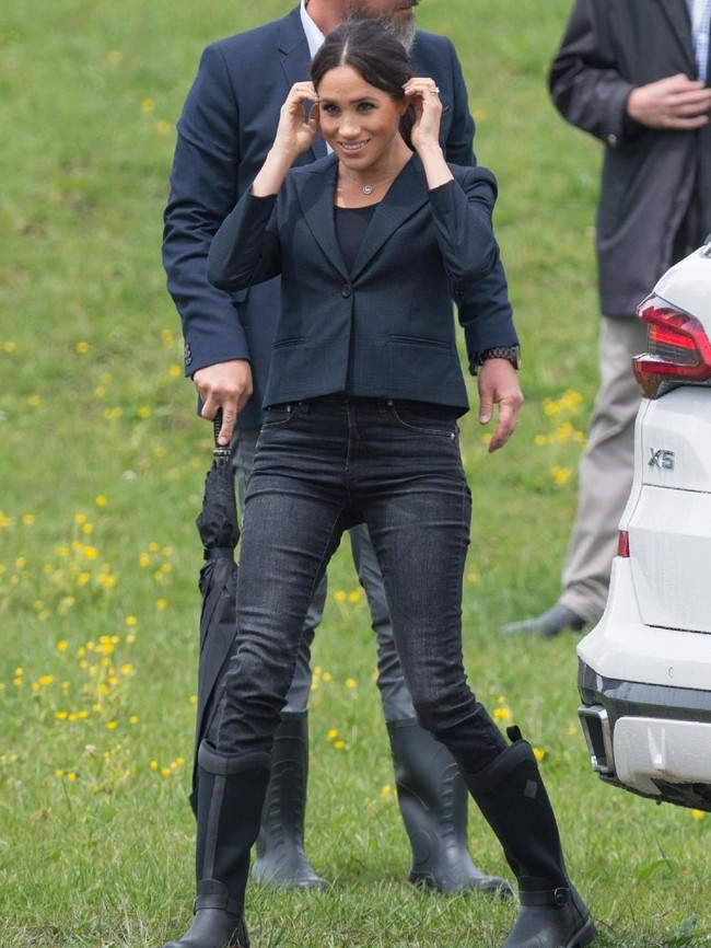 Cuaca yang kurang bersahabat tentu bukan penghalang bagi Meghan Markle untuk bersolek. Ia berbalut cropped-blazer hitam dengan skinny jeans serta boots berwarna senada. (Foto: Getty Images)