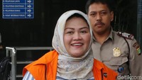 Neneng Hassanah tampak tersenyum saat tiba di gedung KPK.