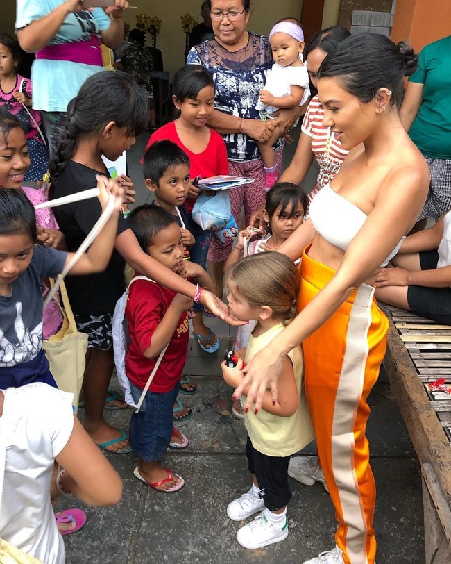 Kourtney tampaknya tak hanya menghabiskan waktu di dalam hotel. Ia juga berinteraksi dengan warga lokal. Dalam foto ini, ia tampak bertemu dengan anak-anak yang terlihat gemas dengan Reign. Ketika itu, Kourtney menggunakan bralette putih dan celana sporty. Foto: Instagram @kourtneykardash