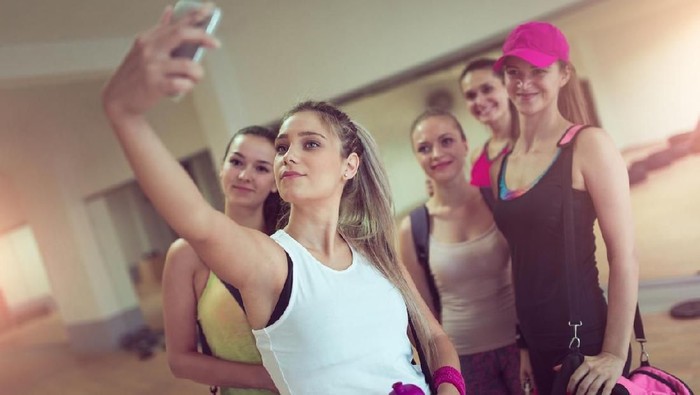 923751630 Woman sitting and taking selfie after exercising.