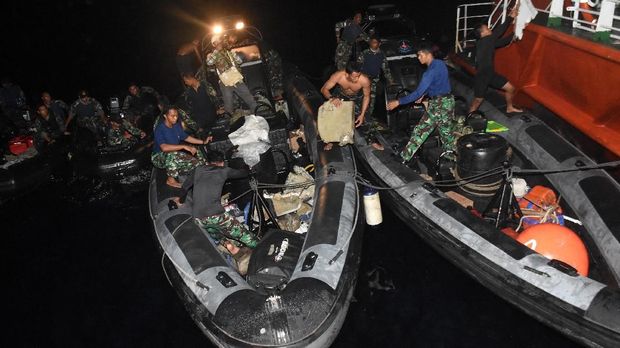 Prajurit TNI mengevakuasi puing dan jenazah korban kecelakaan pesawat Lion Air JT-610 ke Kapal Basarnas (KN SAR Jakarta) di perairan Karawang, Jawa Barat, Senin (29/10) malam.