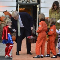 Melania mengikuti acara trick-or-treat di Gedung Putih dibalut coat dress kuning bermotif plaid dari Bottega Veneta. Padanan bersama sepatu pump hitam sederhana melengkapi kostum Halloween Melania Trump. Foto: Dok. Getty Images