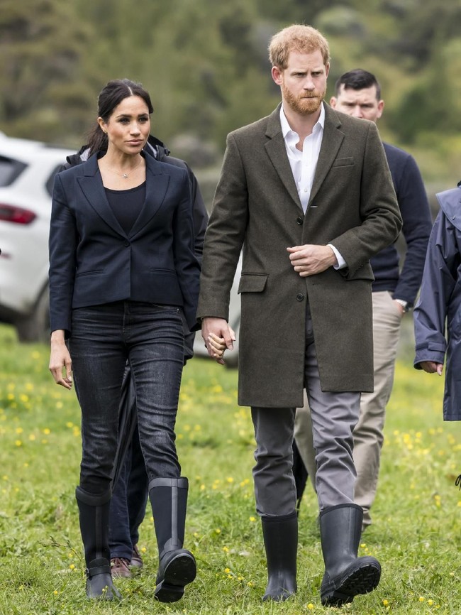 Meghan Markle dan Pangeran Harry mengunjungi hutan lindung Queens Commonwealth Canopy di sela kunjungan resminya ke Auckland, Selandia Baru, Selasa (30/10/2018) pagi. Dalam kesempatan tersebut, sejoli ini kompak dengan padanan blazer, jeans, dan boots. Cuaca mendung dan hujan menyambut kedatangan mereka kala itu. (Foto: Getty Images)