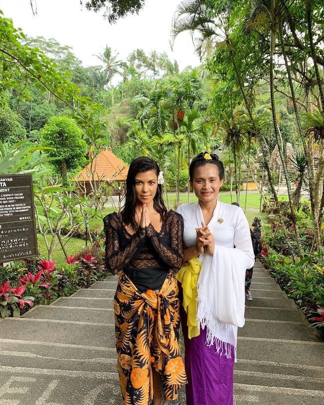 Selama liburan di Bali, Kourtney Kardashian terlihat menerapkan gaya busana yang menarik. Dalam salah satu fotonya, ibu tiga anak tersebut terlihat memakai kain sebagai sarung. Kain tradisional Indonesia itu tampak kontras dengan busana berenda transparan yang digunakannya. Foto: Instagram @kourtneykardash