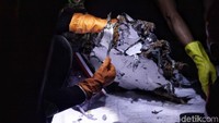 Petugas gabungan memeriksa puing-puing Pesawat Lion Air JT-610 di Pelabuhan JICT 2,  Jakarta Utara, Senin (29/10) malam.