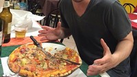 Pemain film trilogi John Wick ini sangat senang dengan menu pizza sebagai makan malamnya. Satu pan pizza besar ini, mampu ia habiskan sendiri lho. Foto: Hollywood - Istimewa