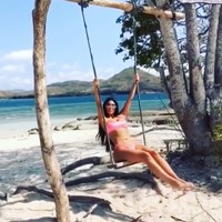 Kim Kardashian berbikini pink sembari bermain ayunan di tepi pantai. (Foto: Dok. Instagram/kimkardashian)
