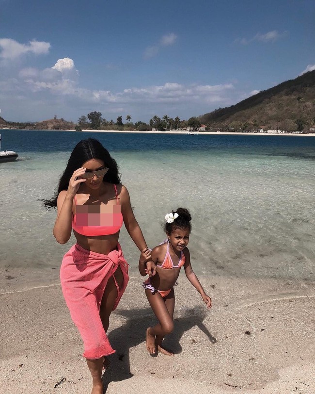 Kim Kardashian tampil kompak dengan sang putri, North, dalam balutan bikini bernuansa pink, saat bermain di pantai. (Foto: Instagram/@kimkardashian)