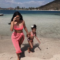Kim Kardashian tampil kompak dengan sang putri, North, dalam balutan bikini bernuansa pink, saat bermain di pantai. (Foto: Instagram/@kimkardashian)