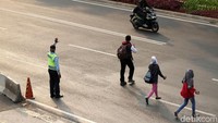 Warga menyeberang di jalan karena JPO mulai direvitalisasi.