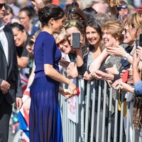 Rok Givenchy menjadi pilihannya. Namun, rok model pleats yang berbahan menerawang itu mengekspos pakaian dalam Meghan. (Foto: Dominic Lipinski-Pool/Getty Images)