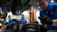 Seorang mahasiswa sedang membuat komponen kendraan. instimewa