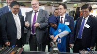  Menteri Ekonomi dan Energi Jerman Peter Altmaier (tengah) dan Menteri Perindustrian Republik Indonesia Airlangga Hartarto (ketiga dari kiri) mengamati komponen yang ditunjukkan oleh mahasiswi Politeknik Manufaktur. istimewa