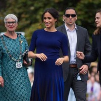 Meghan menyempurnakan gayanya dengan sepasang suede heels berwarna navy favoritnya dari label Manolo Blahnik. (Foto: Dominic Lipinski-Pool/Getty Images)