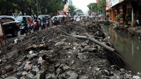 Tumpukan tanah hasil galian lubang saluran drainase itu dibiarkan menumpuk dipinggir jalan.