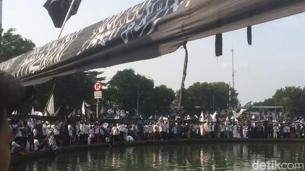 Bendera dipegang memutari bundaran air mancur
