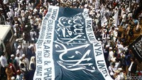 Massa aksi membentangkan spanduk besar bertuliskan kalimat tauhid. Spanduk ini dibawa sebagai penanda tema yang diusung dalam demonstrasi.