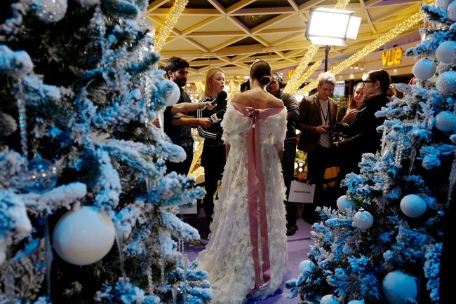 Bagian belakang gaun dipermanis dengan aksen pita  berwarna pink yang menjuntai panjang. Foto: Getty Images