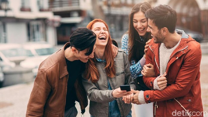 Girl showing her friends something funny on her smart phone.