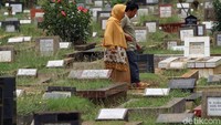 Salah seorang warga berjalan mencari makam keluarganya di TPU Menteng Pulo, Jakarta.