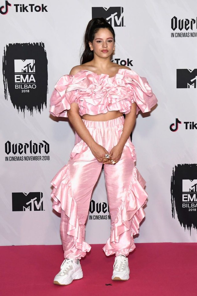 Penyanyi Spanyol Rosalia menarik perhatian --tapi bukan dalam artian yang baik-- dengan kemben dan jogger satin beraksen ruffle. Oke, mau ikut parade kostum ke mana, Rosalia? Foto: Getty Images