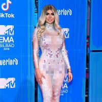 Bintang reality TV Chloe Ferry juga mencoba bergaya futuristik memakai jumpsuit ketat putih dengan hiasan kristal nuansa ungu. Tapi sepertinya ia tampak kurang nyaman mengenakannya. Foto: Getty Images