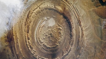 Mata Sahara ini berada di Mauritania, Afrika. Formasi batu, fosil, sampai jejak alien dikaitkan dengan fenomena yang hanya bisa dilihat dari angkasa ini. Foto: NASA