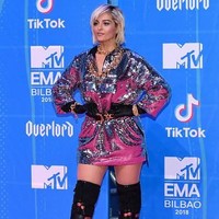 Penyanyi dan penulis lagu Bebe Rexha tampil mencuri perhatian dengan dress ber-hoodie warna silver. Gayanya semakin nyentrik dengan belt, sarung tangan, dan kalung rantai. Foto: Getty Images