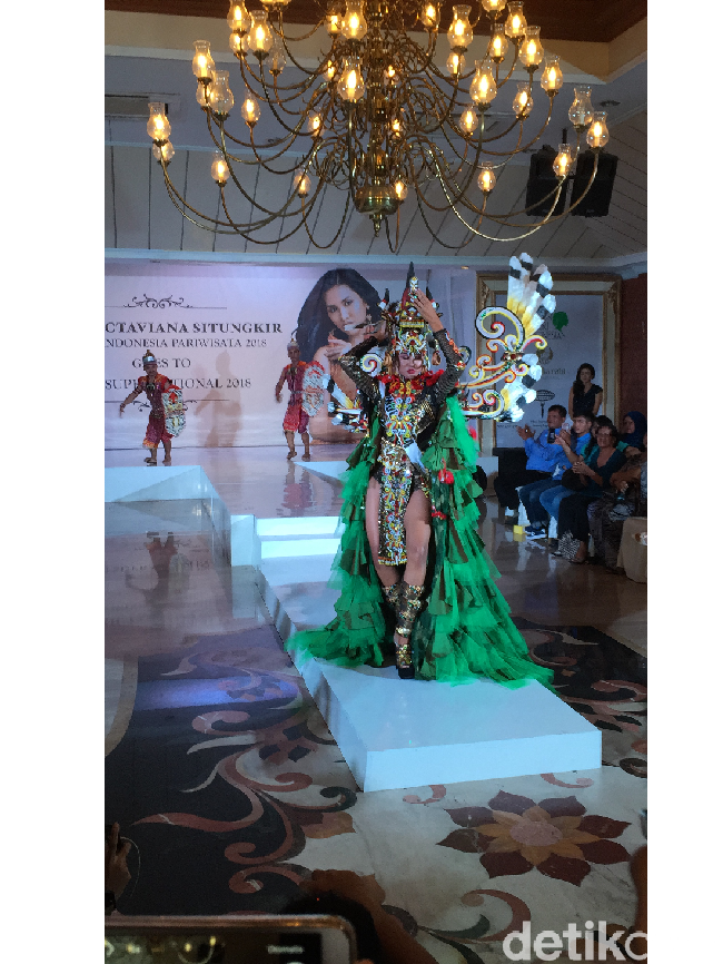 Wilda memakai topeng dengan bentuk mata yang besar, paruh dan mulut yang terbuka lebar. Sementara taring yang mencolok hadir sebagai perwujudan kekuatan dan kehormatan. Material ruffle berwarna hijau yang turut menghiasi kostum mewakili daun pisang yang diyakini sebagai bentuk kesuburan dan kesejahteraan. (Foto: Daniel Ngantung/Wolipop)