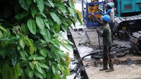 Para pekerja bahu membahu mengerjakan turap.