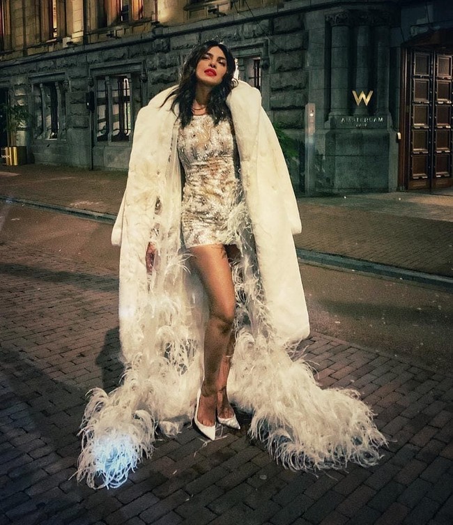 Untuk menahan dinginnya suhu di Kota Amsterdam pada malam hari, Priyanka memadukan gaunnya dengan coat bulu super tebal saat berpose di luar ruangan. Foto: Instagram/@priyankachopra