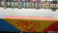 Coretan di beberapa titik itu merusak keindahan danau yang sudah dicat warna-warni.