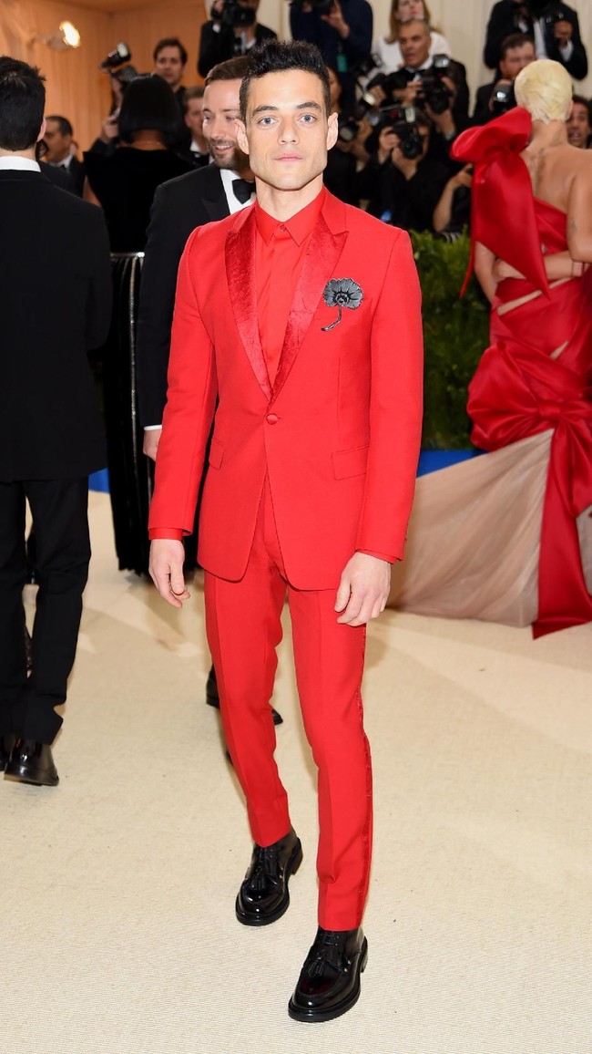 Setelan serba merah yang mencolok dipilih Rami Malek sehingga penampilannya tak terasa monoton. (Foto: Getty Images)