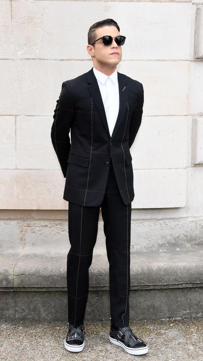 Berbeda dari Freddie Mercury, gaya minimalis dalam palet warna monokromatik menjadi andalan Rami Malek. Tengok saja gaya aktor keturunan Mesir ini saat menghadiri fashion show Dior di Paris Fashion Week beberapa waktu lalu. (Foto: Getty Images)