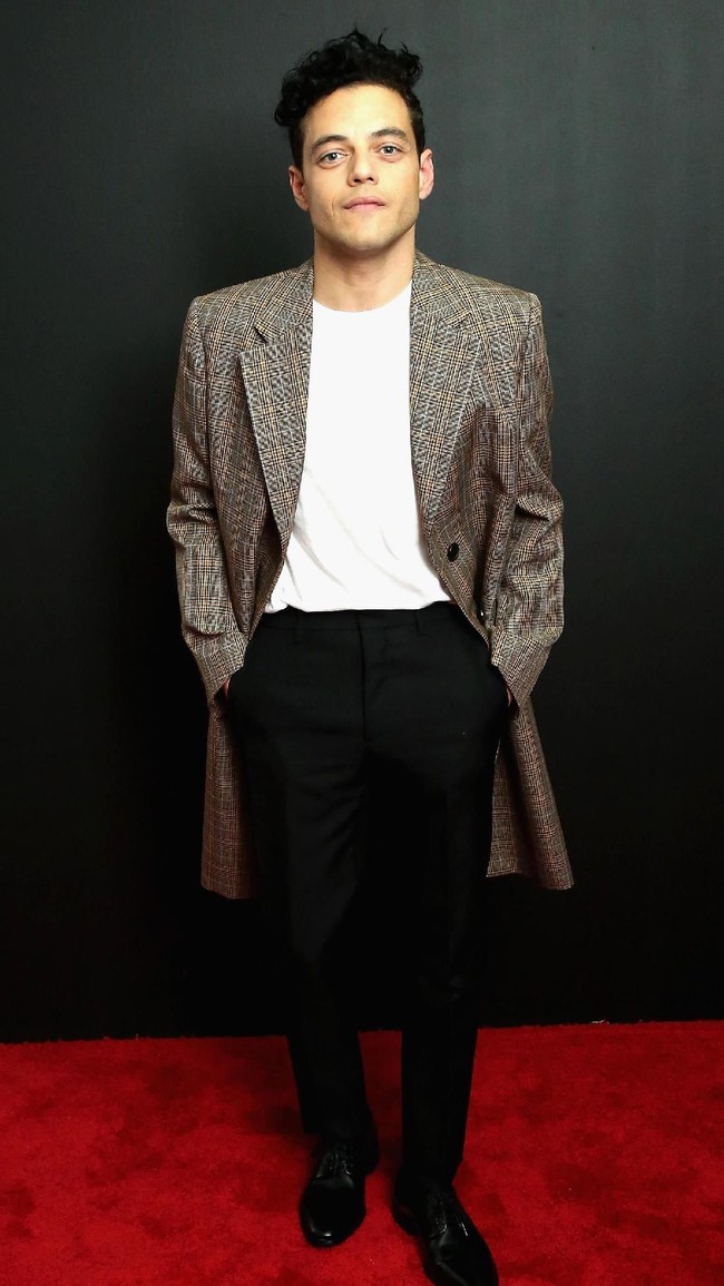 Kaus yang dibungkus blazer panjang dan celana bahan seperti yang diandalkan Rami saat menghadiri fashion show Calvin Klein ini juga bisa jadi inspirasi buat para pria yang ingin tampil preppy tanpa berlebihan. (Foto: Getty Images)