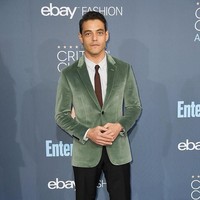 Rami memakai blazer hijau velvet yang meninggalkan kesan mewah. Dasi coklatnya disenadakan dengan sepatu kulitnya. (Foto: Getty Images)