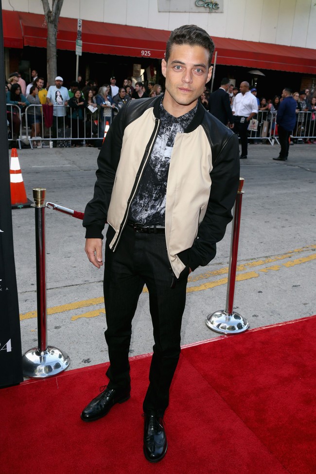 Untuk gaya yang lebih kekinian, Rami memadukan busana formalnya dengan jaket bomber yang edgy. Foto: Getty Images