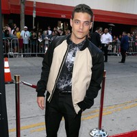 Untuk gaya yang lebih kekinian, Rami memadukan busana formalnya dengan jaket bomber yang edgy. Foto: Getty Images