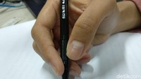 Kamu memegang pulpen atau pensil di antara jari telunjuk dan jari tengah? Itu artinya kamu orang yang cukup supel dan berusaha tidak mendrama. Biasanya tipe orang ini berprinsip pada maafkan, lupakan, dan move on. Foto: Widiya Wiyanti/detikHealth