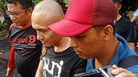 Rohandi dibawa ke Polres Jakut pukul 14.50 WIB. Dia mengenakan kaos hitam dan celana pendek, Rohandi diantar dua anggota polisi ke dalam mobil.  (Foto: Eva Safitri/detikcom)