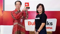 Natalia Firmansyah selaku Chief Financial Officer Bukalapak memberikan cinderamata kepada Bapak Ghafur Dharmaputra selaku Plt. Deputi Bidang Koordinasi Perlindungan Perempuan dan Anak Kementerian Koordinator Bidang Pembangunan Manusia dan Kebudayaan, sebagai bentuk apreasi terhadap dukungannya dalam acara Festival Srikandi Bukalapak Nusantara. Foto: dok. Bukalapak