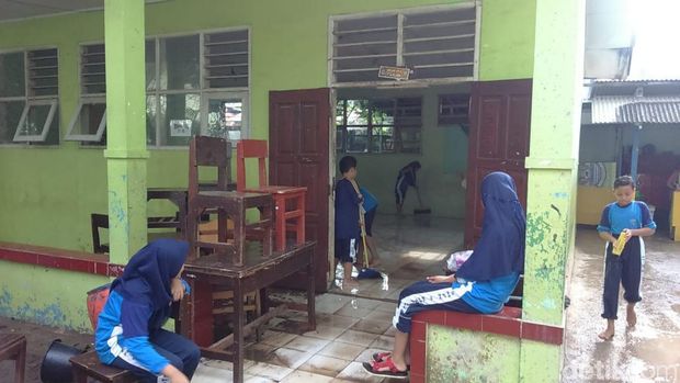 Murid dan guru SMPN Bekasi membersihkan sisa banjir pada Senin (12/11/2018)