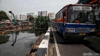 Angkutan umum terlihat melintas diantara pengerjaan proyek turap kali Sentiong.