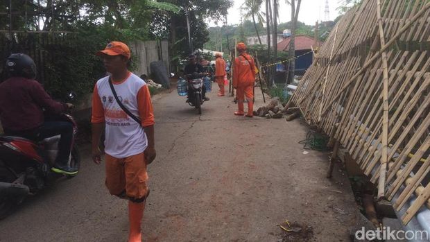 Petugas Perbaiki Jalan Longsor di Setu Cipayung Arah Bekasi