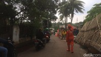 Petugas PPSU atau pasukan oranye ikut memperbaiki dan mengatur arus kendaraan roda dua.