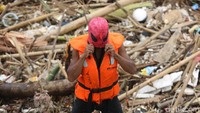 Bersama dengan kawan-kawan lainnya, Spiderman membersihkan sampah yang berserakan akibat terseret air kiriman dari Bogor dan sekitarnya pada Minggu (11/11/2018) sore.